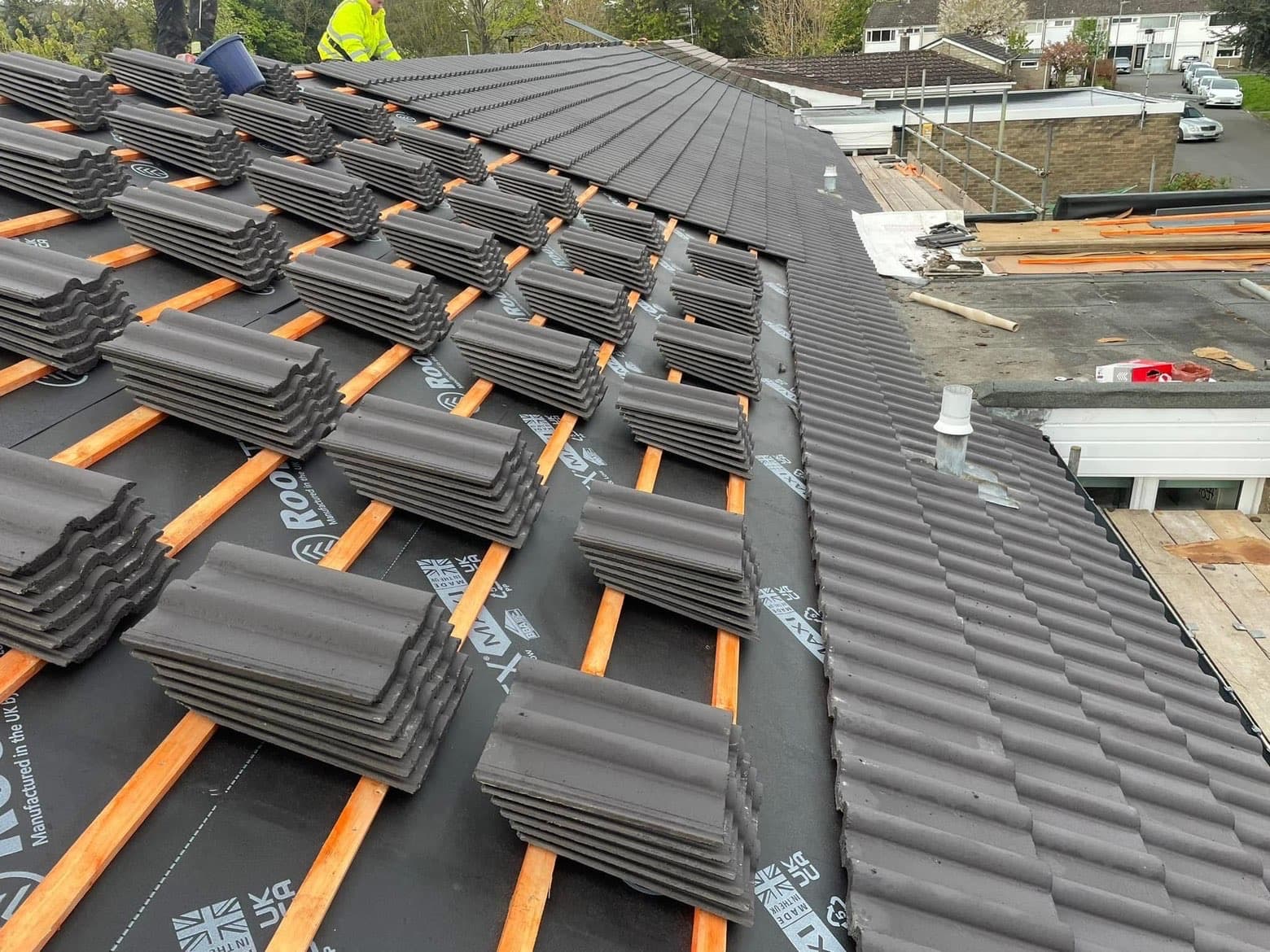 RML roofers laying new concrete tiles over fresh battens and membrane